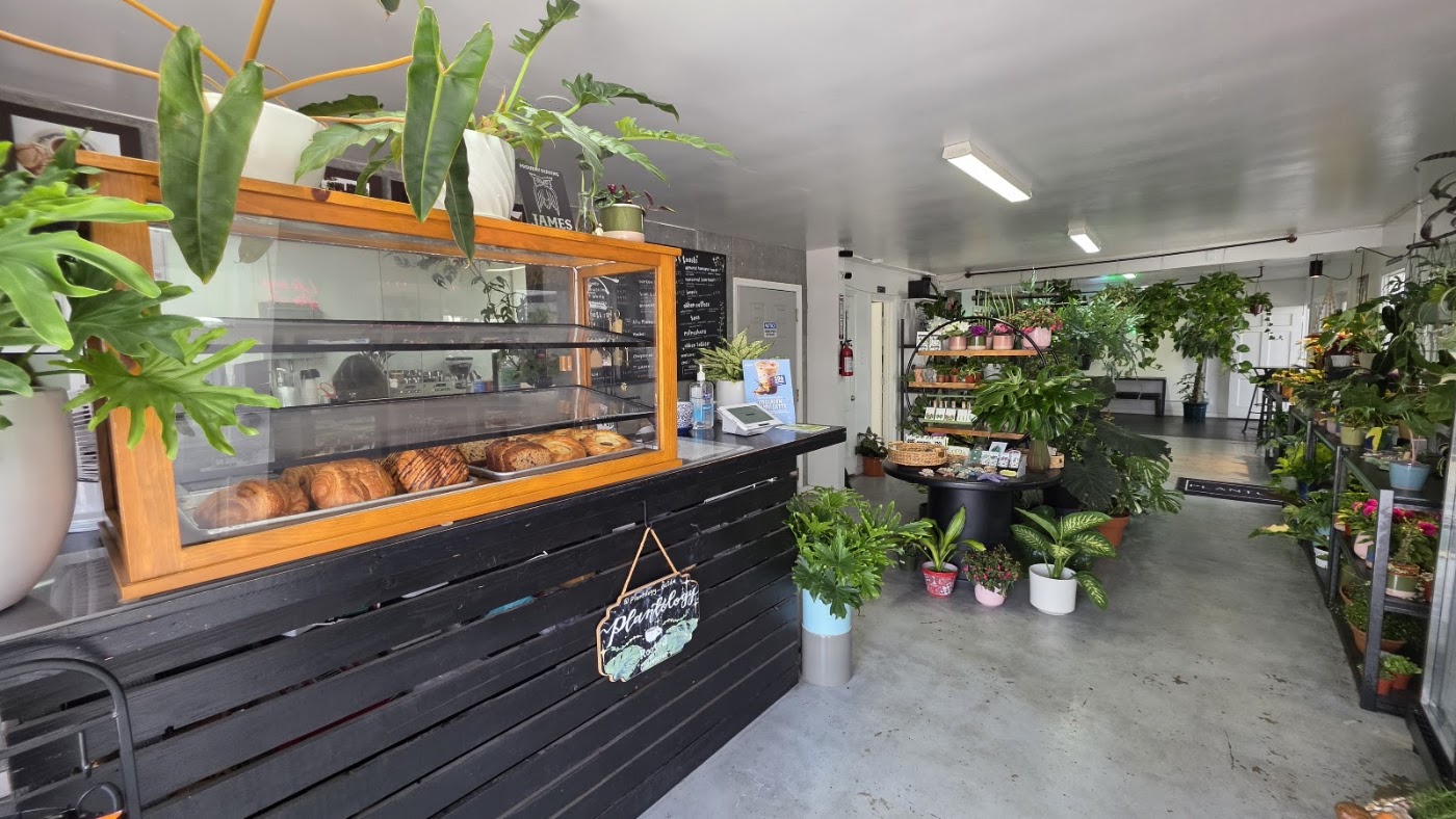 Plantology Cafe counter with pastries, menu boards and plants